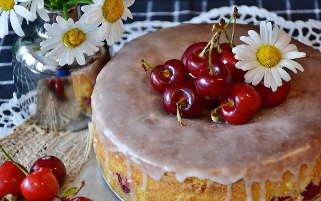 A rustic golden layer cake with a glossy chocolate ganache